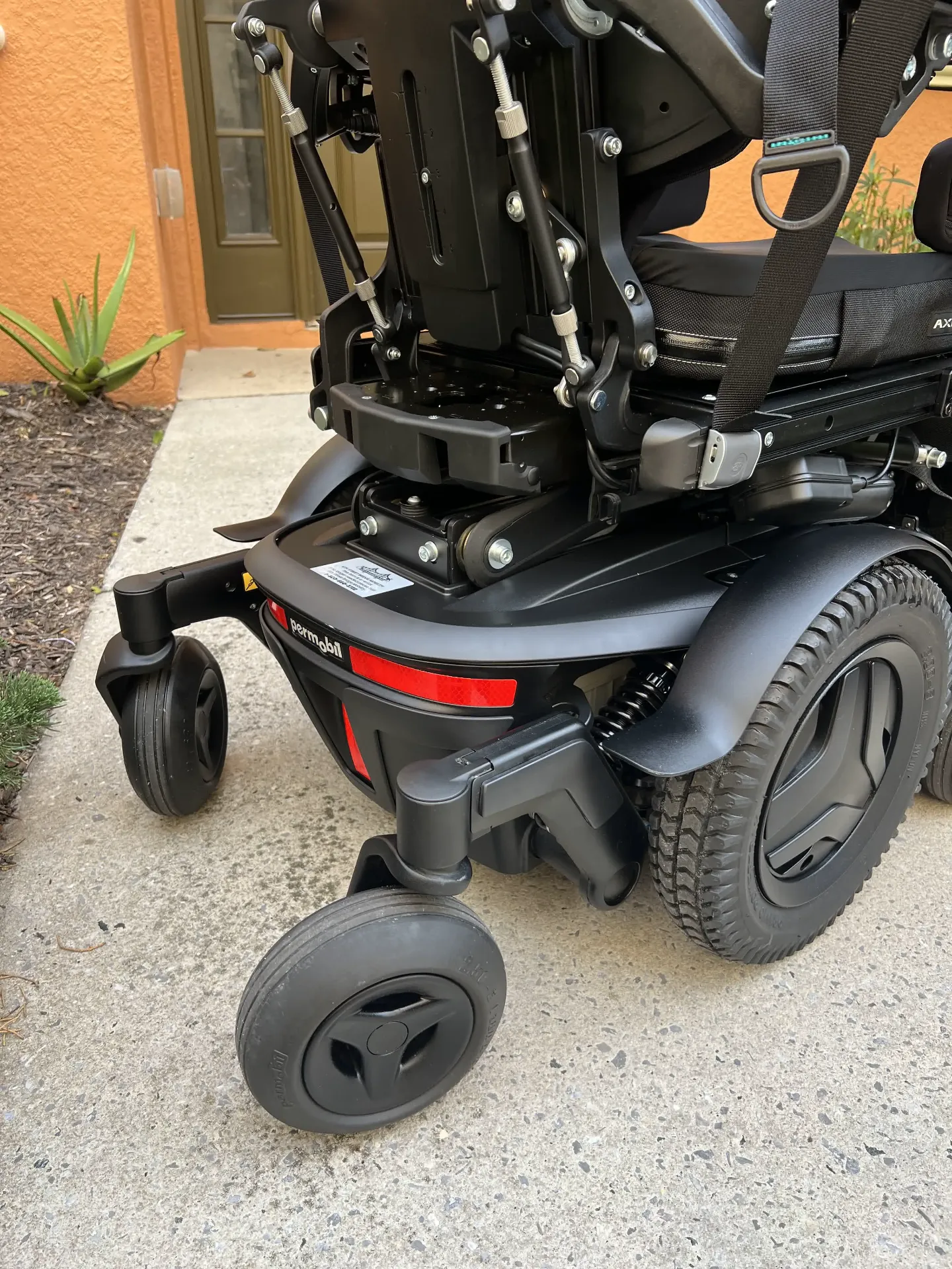 Permobil M3 Corpus power wheelchair side view showing drive wheel and base